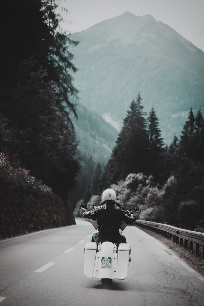 pexels-photo-1367146-1367146 A solo motorcyclist enjoys a picturesque ride through a winding mountain road surrounded by lush forest.